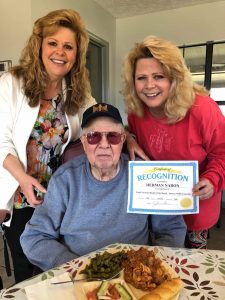 Angels for the Elderly memory care resident with family members holding certificate in Montgomery, AL