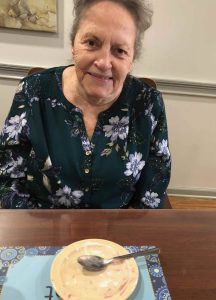 Angels for the Elderly memory care resident sitting at table after dessert in Montgomery, AL