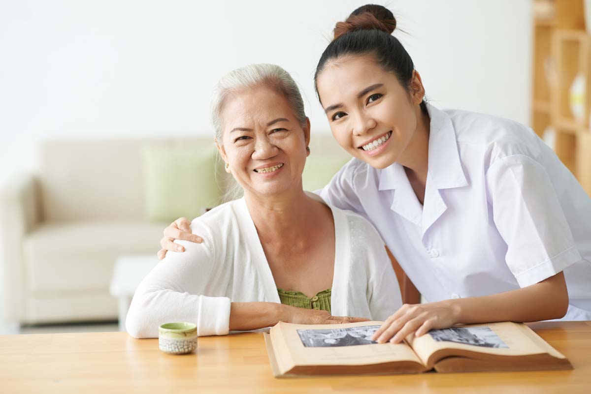 Legacy Ridge at Bookstone | Senior woman reading with caregiver