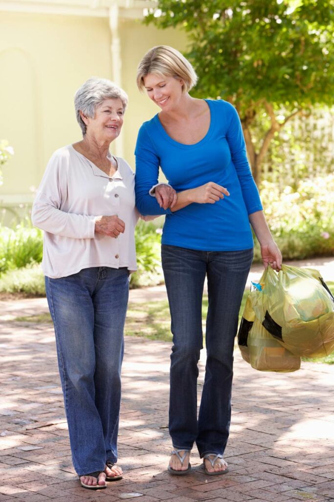 Legacy Ridge at Bookstone | Senior woman walking with caregiver outdoors
