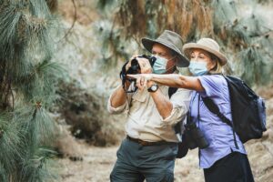 Atlas Senior Living | Seniors walking with binoculars through the wilderness