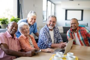 Atlas Senior Living | A group of happy seniors gathered at a table for coffee and socializing