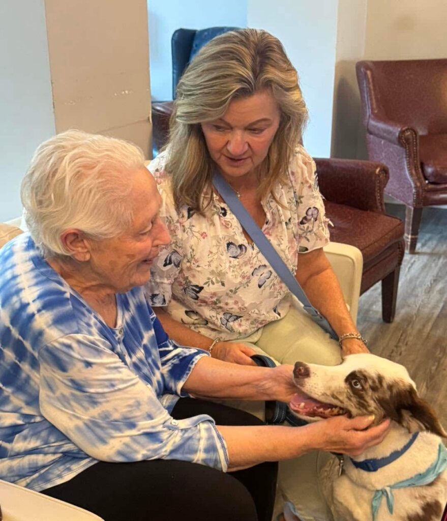 Resident enjoying pet therapy and personalized support at Madison Heights at Evans, a Memory Care community in Evans, GA.