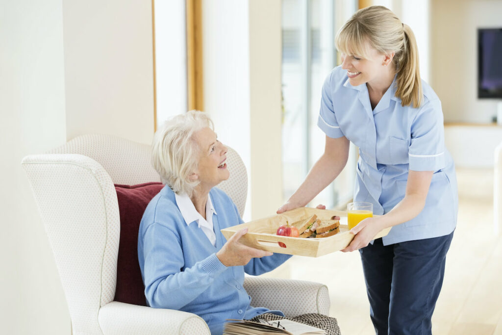 Oakview Park | Happy senior being given breakfast by caregiver