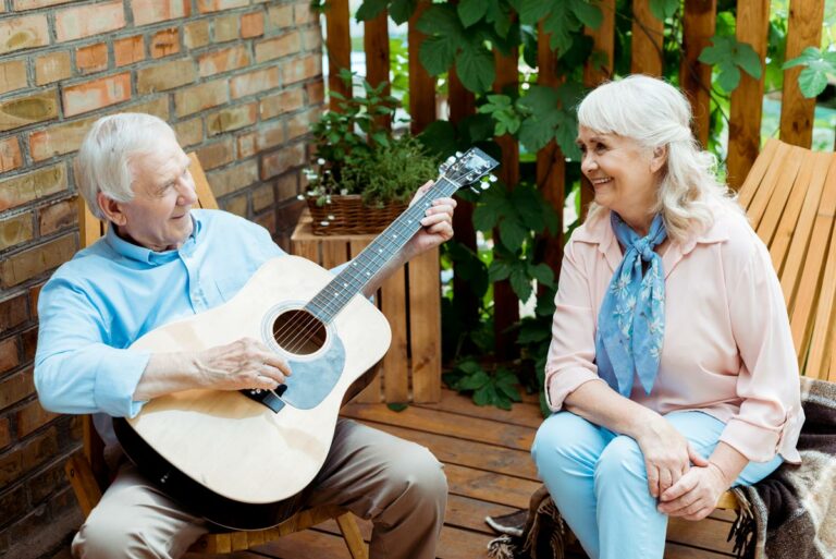 The Goldton at Spring Hill | Senior man playing guitar beside senior woman