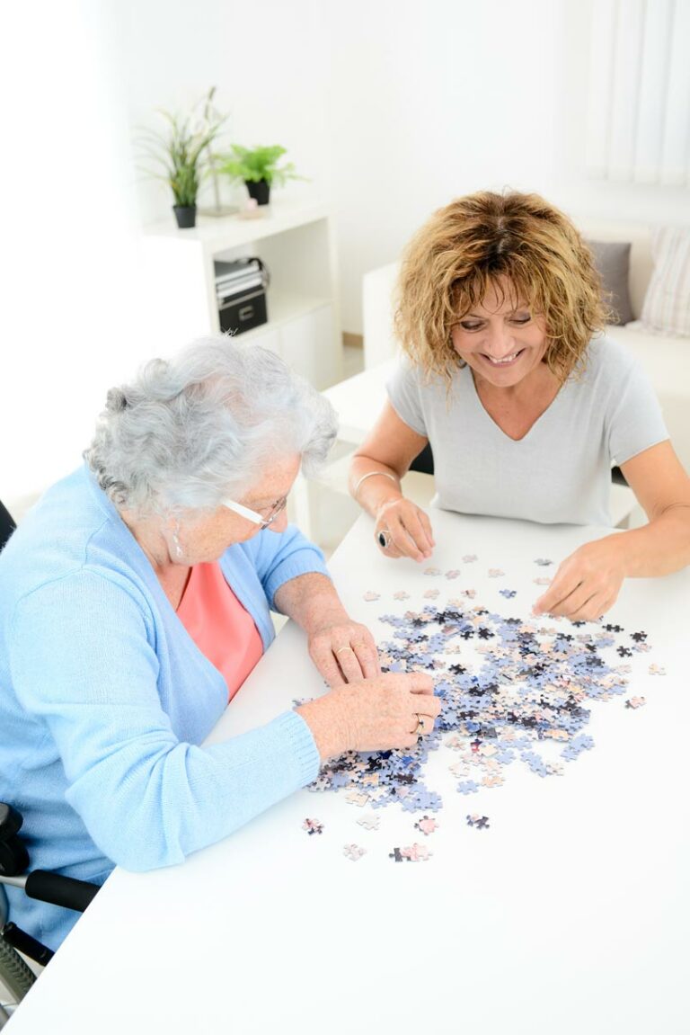 The Goldton at Spring Hill | Senior woman completing puzzle with caregiver
