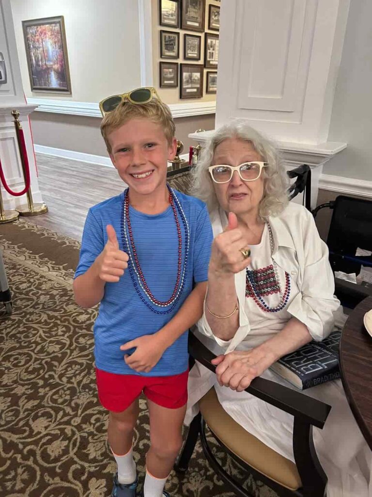 Resident at The Goldton at Spring Hill sharing a joyful moment with a young family visitor in Spring Hill, Tennessee.