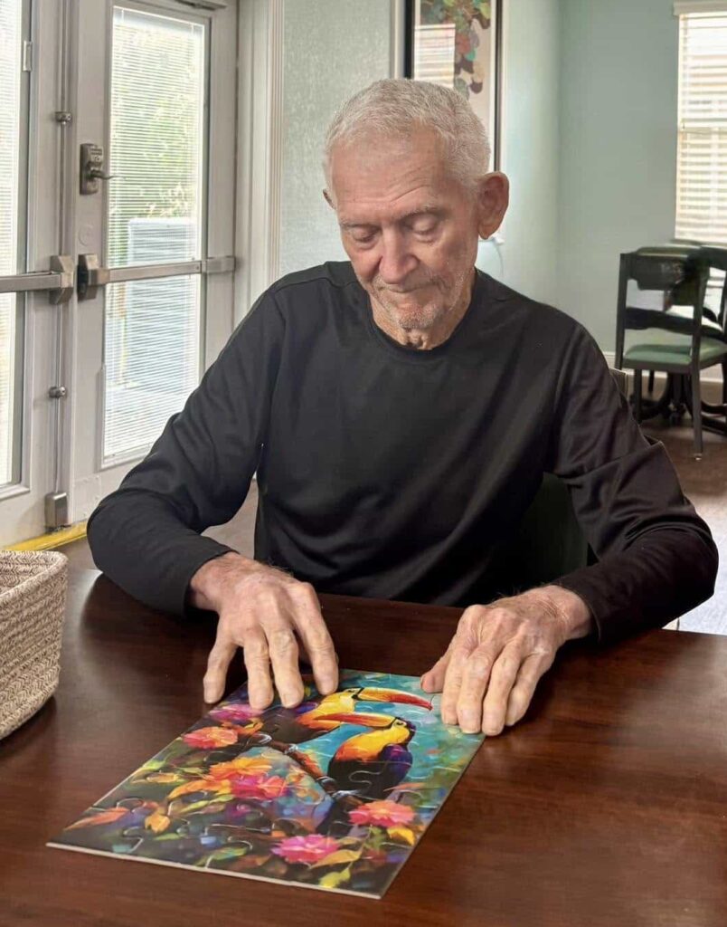 Resident enjoying a cognitive puzzle activity at The Goldton at St. Petersburg Memory Care in Florida