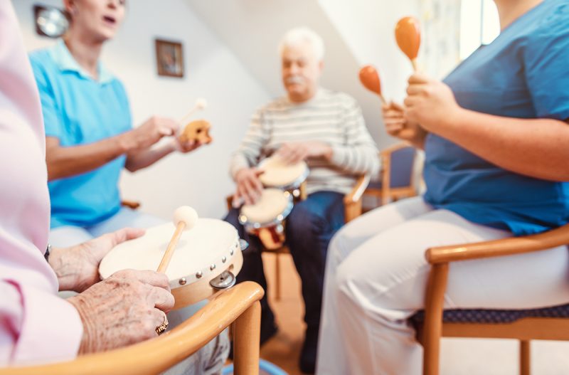 Atlas Senior Living | Seniors in nursing home making music with rhythm instruments