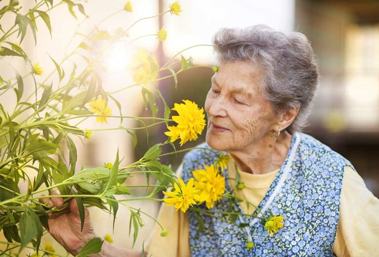 Atlas Senior Living | Woman smelling flowers